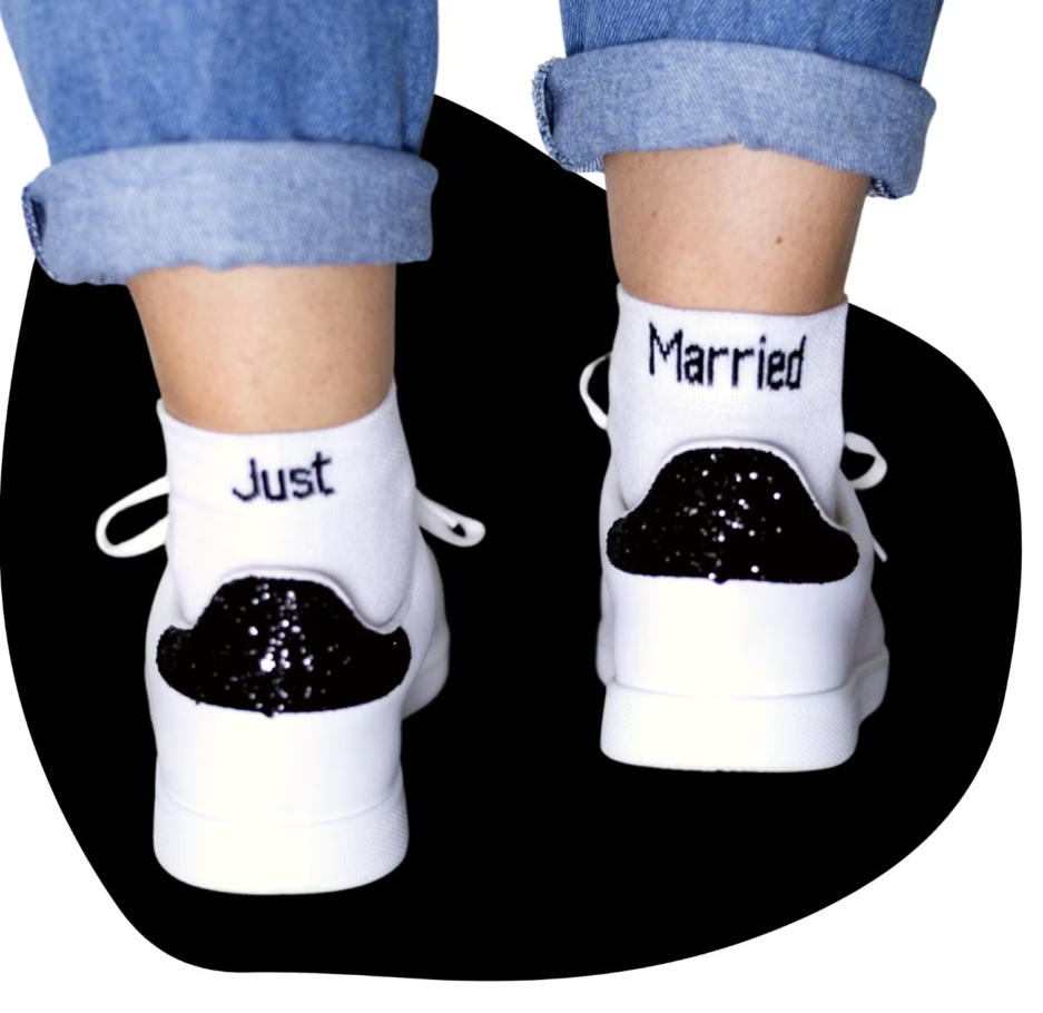 (Chaussettes Just married) Chaussettes blanches avec écrit en noir "Just" sur la chaussette gauche et "Married" sur la chaussette droite. Les deux ensemble font les chaussette "Juste Maried"