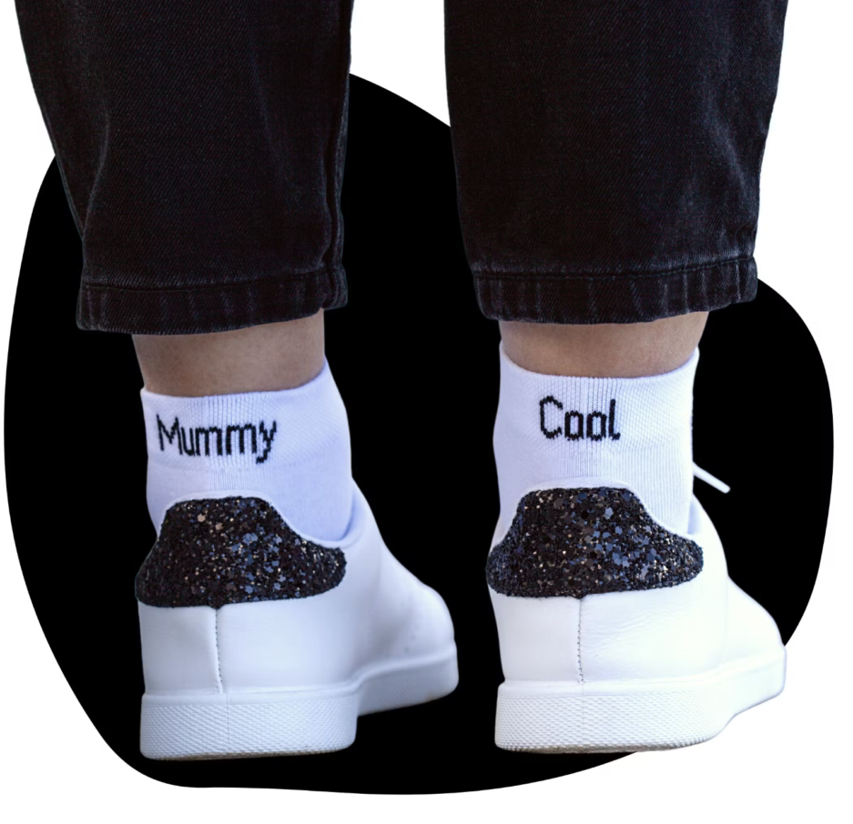 Chaussette Mummy Cool. image avec une paire de chaussette blanche écris Mummy sur la chaussette gauche et cool sur la droite. Créant ainsi un message super fun et original.
