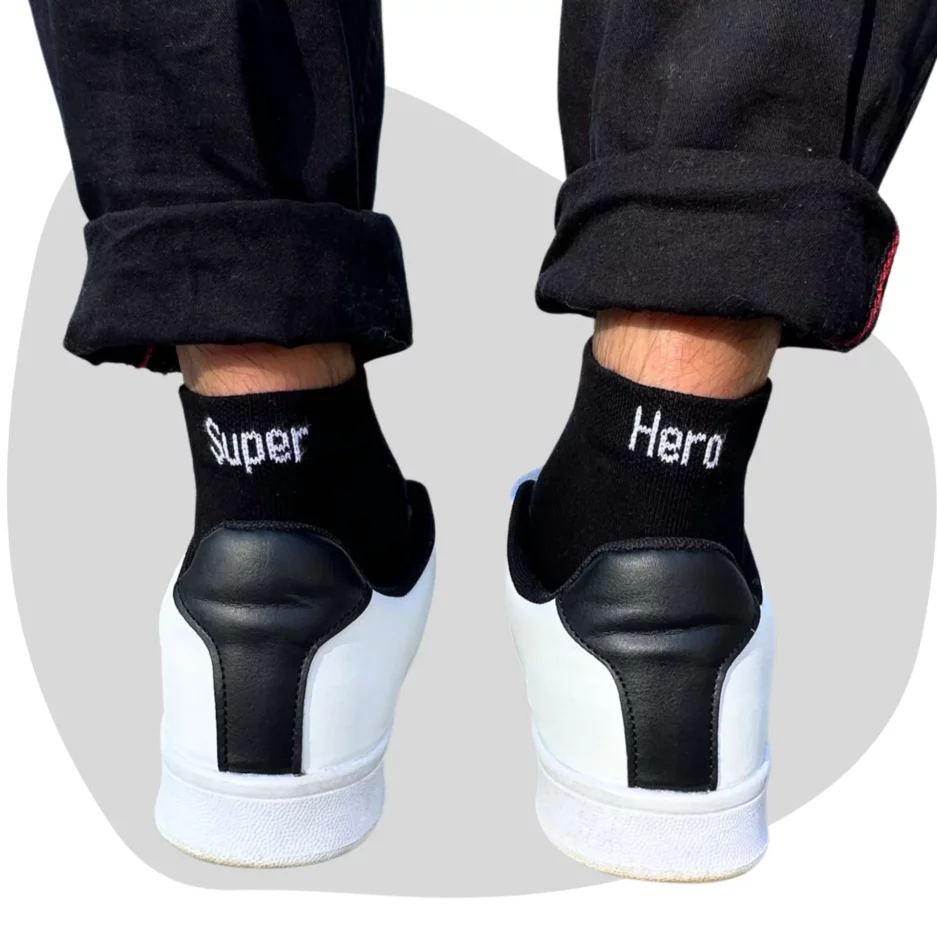 Chaussettes super héro. paire de chaussette noire écris 'super" à l'arrière de la gaucher et " hero" à l'arrière de la droite. écriture blanche.